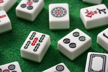 KYIV, UKRAINE - 30 HAZİRAN 2019: Yeşil kadife yüzeyinde işaretleri ve sembolleri olan beyaz mahjong oyununun seçici odak noktası