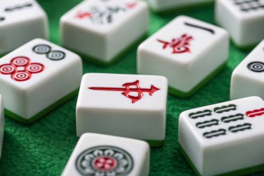 KYIV, UKRAINE - 30 HAZİRAN 2019: Yeşil kadife yüzeyinde işaretleri ve sembolleri olan beyaz mahjong oyununun seçici odak noktası