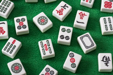 KYIV, UKRAINE - 30 HAZİRAN 2019: Yeşil kadife yüzeyinde işaretleri ve karakterleri olan beyaz mahjong oyun fayanslarının üst görünümü