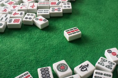 KYIV, UKRAINE - 30 HAZİRAN 2019: Yeşil kadife yüzeyinde işaretleri ve karakterleri olan beyaz mahjong oyunu fayansları