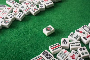 KYIV, UKRAINE - 30 HAZİRAN 2019: Yeşil kadife yüzeyinde işaretleri ve karakterleri olan beyaz mahjong oyunu fayansları