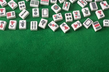KYIV, UKRAINE - 30 HAZİRAN 2019: Yeşil kadife yüzeyinde işaretleri ve karakterleri olan mahjong oyun fayanslarının üst görünümü