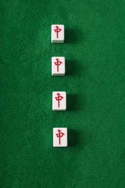 KYIV, UKRAINE - 30 HAZİRAN 2019: Yeşil kadife yüzeyindeki karakterlerin yer aldığı mahjong oyun kiremitlerinin üst görünümü