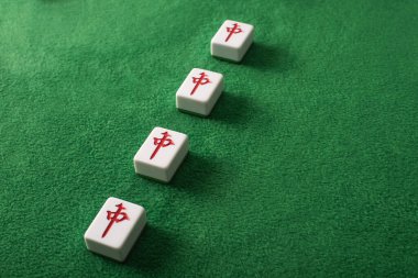 KYIV, UKRAINE - 30 HAZİRAN 2019: yeşil kadife yüzeyinde karakterleri olan bir dizi mahjong oyunu fayansları