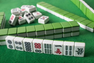 KYIV, UKRAINE - 30 HAZİRAN 2019: yeşil kadife yüzey üzerindeki sıraların ve mahjong oyun fayanslarının seçici odağı