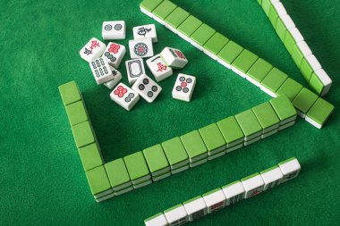 KYIV, UKRAINE - 30 HAZİRAN 2019: sıralar ve yeşil kadife yüzey üzerindeki mahjong oyun fayansları yığını