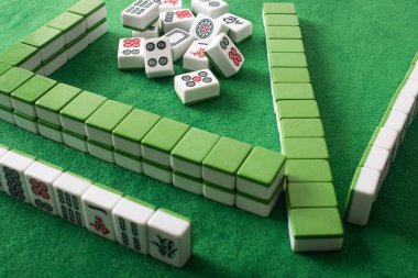 KYIV, UKRAINE - 30 HAZİRAN 2019: sıralar ve yeşil kadife yüzey üzerindeki mahjong oyun fayansları yığını