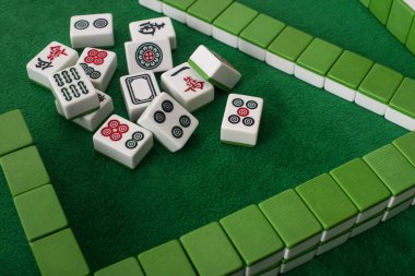 KYIV, UKRAINE - 30 HAZİRAN 2019: sıralar ve yeşil kadife yüzey üzerindeki mahjong oyun fayansları yığını