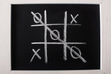 Tahtadaki tic tac toe oyununun üst görünümü ve yaramazların üzerine çizilmiş satır