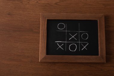 Tahta üzerinde tebeşir ızgarası, ahşap yüzey üzerinde haç ve haç ile tic tac toe oyununun üst görünümü