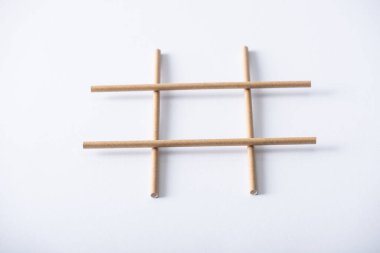 panoramic shot of grid made of paper pipes for tic tac toe game on white surface clipart