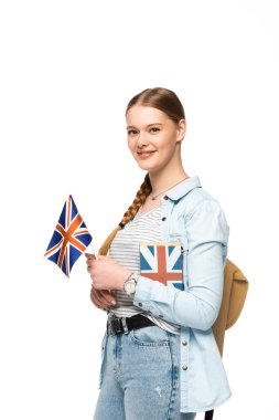 Sırt çantalı gülümseyen güzel öğrenci ve İngiliz bayrağı beyazın üzerinde izole edilmiş.