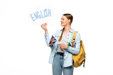 Sırt çantalı gülümseyen güzel öğrenci, İngilizce harfli konuşma balonu ve beyaz üzerine izole edilmiş İngiliz bayrağı.