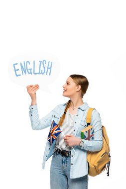 Sırt çantalı gülümseyen güzel öğrenci, İngilizce harfli konuşma balonu ve beyaz üzerine izole edilmiş İngiliz bayrağı.