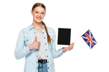 smiling pretty girl with braid holding digital tablet with blank screen and uk flag while showing thumb up isolated on white clipart