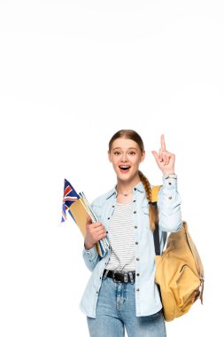 excited girl with backpack pointing up and holding copybooks and uk flag isolated on white clipart