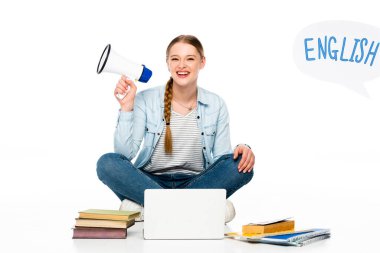 Gülümseyen kız dizüstü bilgisayar, kitap ve kitapların yanında hoparlörle oturuyor, İngilizce harfleri beyaz üzerine izole edilmiş konuşma balonunda.