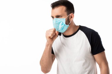 Tıbbi maskeli hasta adam beyaz tenli yalnız öksürüyor. 