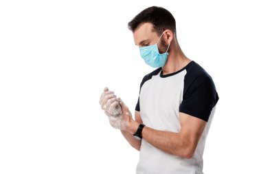 Tıbbi maskeli bir adam kopyalama alanı ile izole edilmiş elleri yıkıyor.