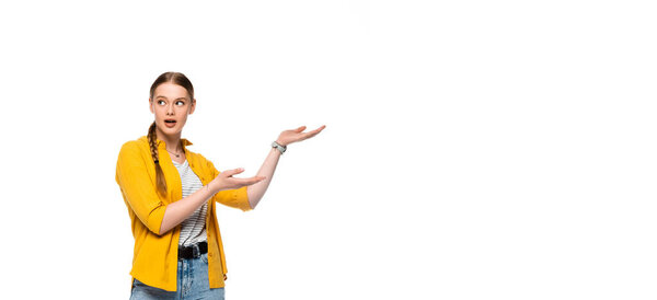 surprised pretty girl with braid pointing with hands aside isolated on white