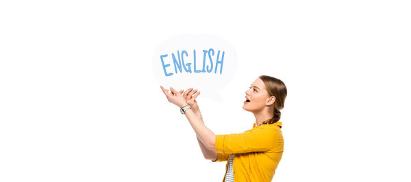 side view of excited pretty girl with braid holding speech bubble with English lettering isolated on white, panoramic shot