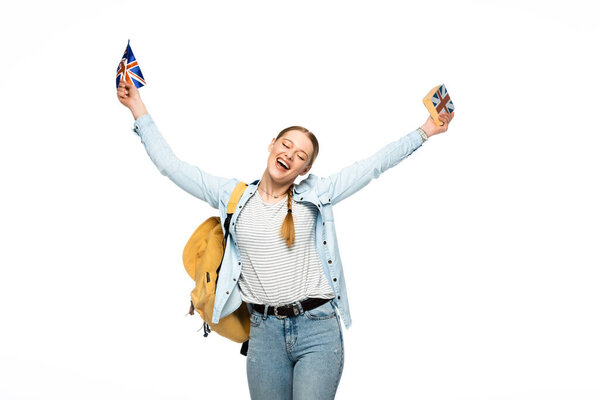 happy student with backpack holding book and British flag isolated on white