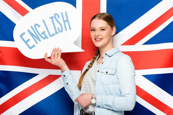 smiling pretty girl with braid holding speech bubble with English lettering on uk flag background
