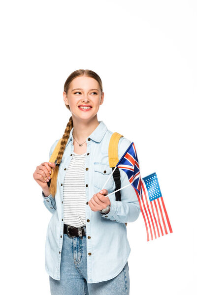 happy girl with braid and backpack holding flags of america and united kingdom isolated on white