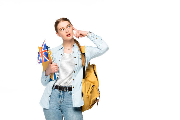 pensive girl with backpack holding copybooks and uk flag isolated on white