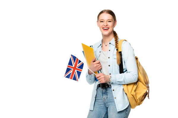 smiling girl with backpack holding copybooks and uk flag isolated on white