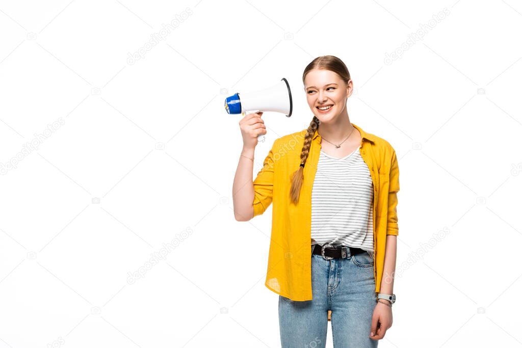 smiling pretty girl with braid holding loudspeaker near ear isolated on white