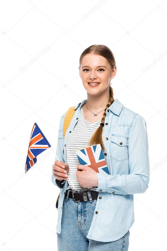 smiling pretty student with backpack holding book and British flag isolated on white