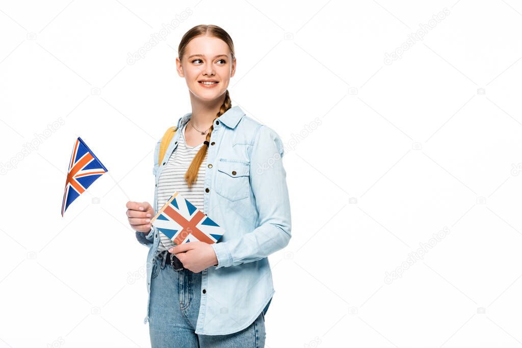 smiling pretty student with backpack holding book and British flag isolated on white