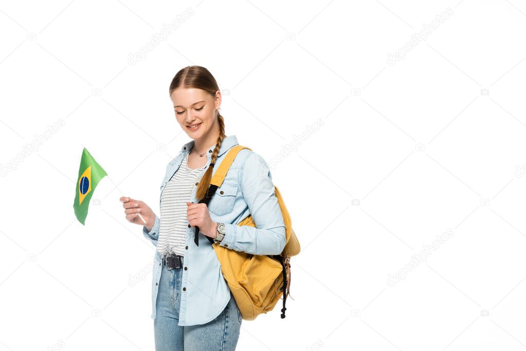 smiling pretty student with backpack holding flag of Brazil isolated on white