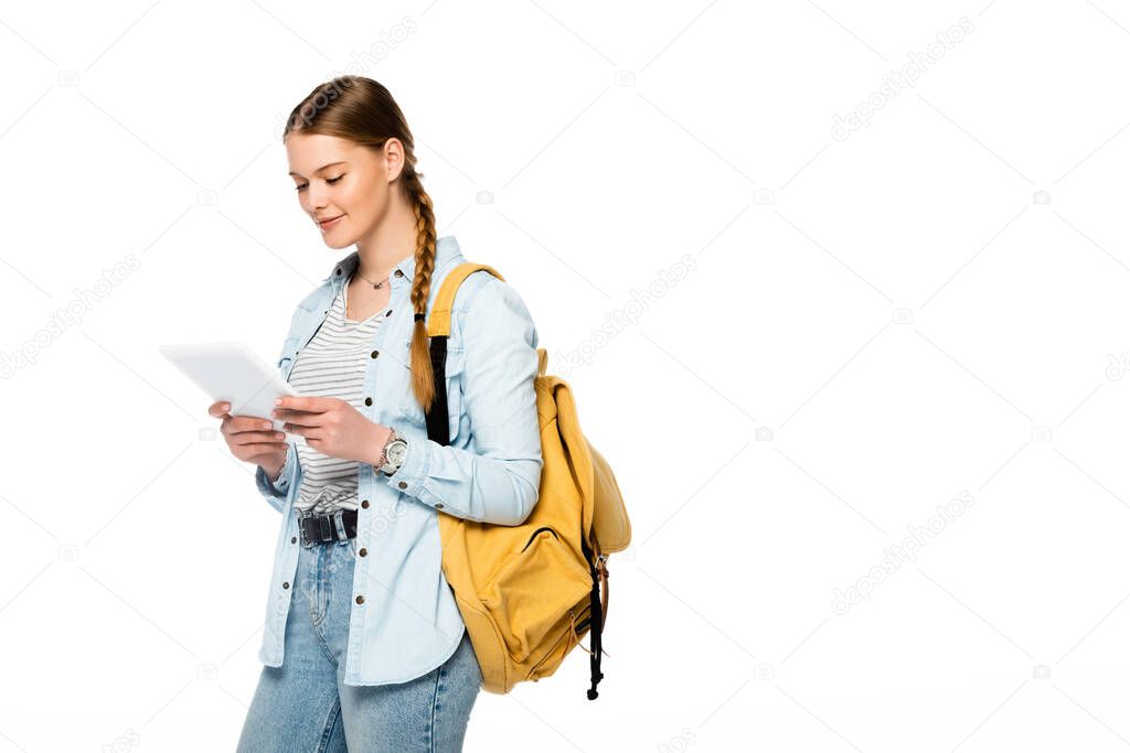 smiling pretty student with backpack holding digital tablet isolated on white