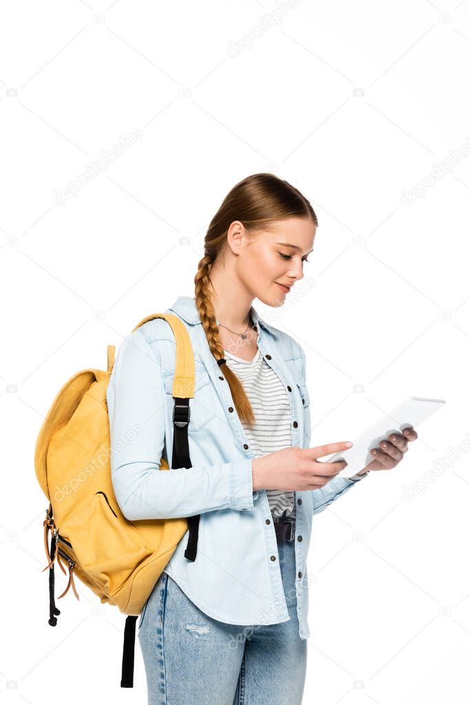 smiling pretty student with backpack holding digital tablet isolated on white