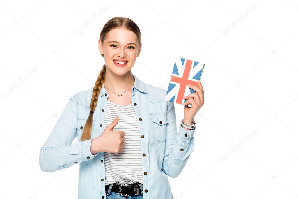 smiling pretty girl with braid holding book with uk flag and showing thumb up isolated on white