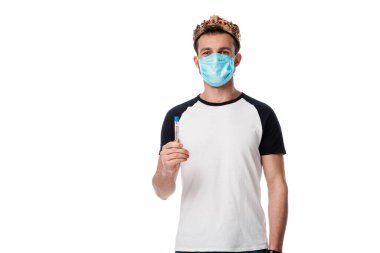 Tıbbi maskeli ve taç takmış bir adam elinde Coronavirus kan örneği olan beyaz harflerle test tüpü tutuyor. 