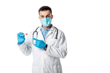 Tıbbi maskeli doktor ve beyaz önlüklü doktor beyaz harflerle izole edilmiş örnek ve koronavirüsle test tüpünü işaret ediyor. 