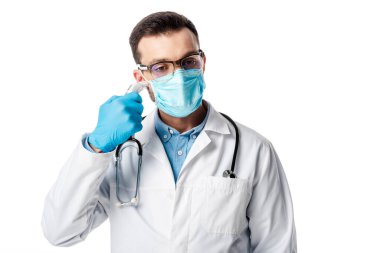 Tıbbi maskeli doktor ve beyaz önlüklü doktor beyaz üzerinde izole edilmiş pirometre kullanıyor. 