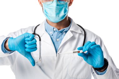 Tıbbi maskeli ve beyaz önlüklü doktorun dijital termometreyi tutuşu ve beyaz üzerinde izole edilmiş baş parmağını göstermesi. 