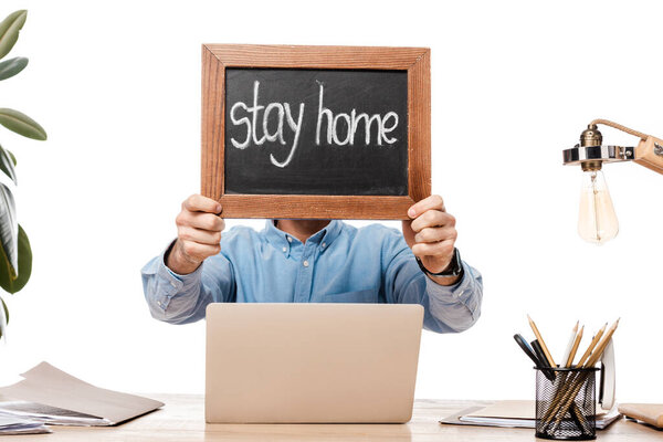 freelancer covering face while holding chalk board with stay home lettering isolated on white 