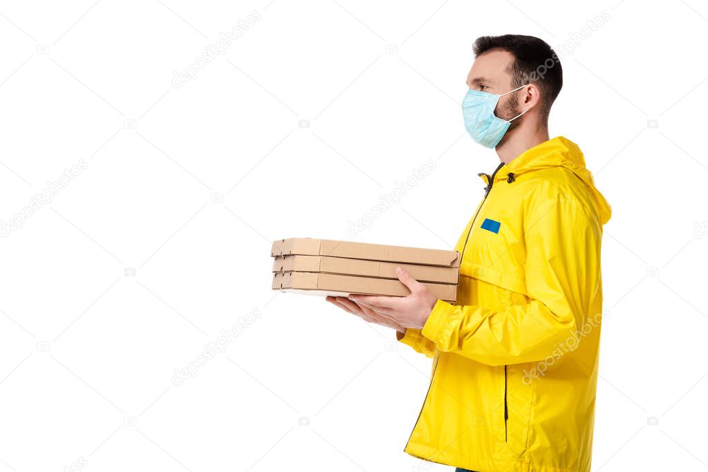 delivery man in blue medical mask holding pizza boxes isolated on white 