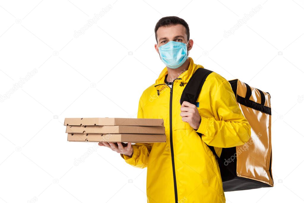 delivery man in medical mask holding cardboard pizza boxes isolated on white 