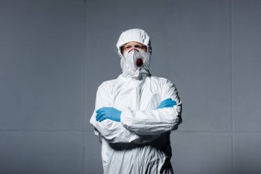 man in personal protective equipment standing with crossed arms on grey clipart