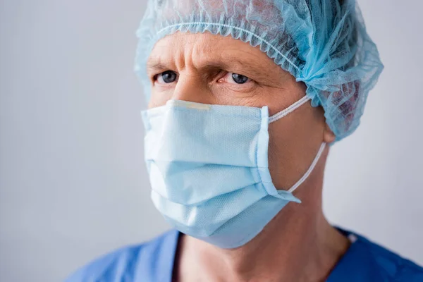 Ώριμος Γιατρός Μπλε Ιατρική Μάσκα Και Καπάκι Που Απομονώνεται Γκρι — Φωτογραφία Αρχείου
