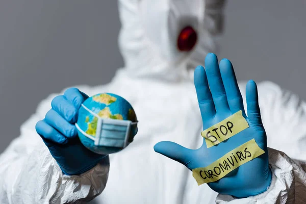 Selective Focus Man Hazmat Suit Holding Globe Showing Hand Stop — Stock Photo, Image