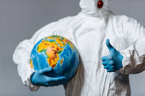 Vedere Decupată Omului Costum Hazmat Ținând Globul Arătând Degetul Mare — Fotografie, imagine de stoc