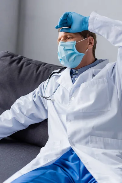 Tired Mature Doctor Medical Mask Sitting Sofa — Stock Photo, Image