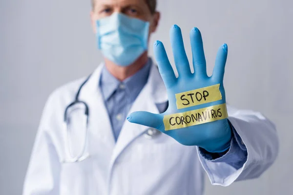 그레이에 코로나 바이러스 문자와 보이는 의사의 선별적 마스크 — 스톡 사진
